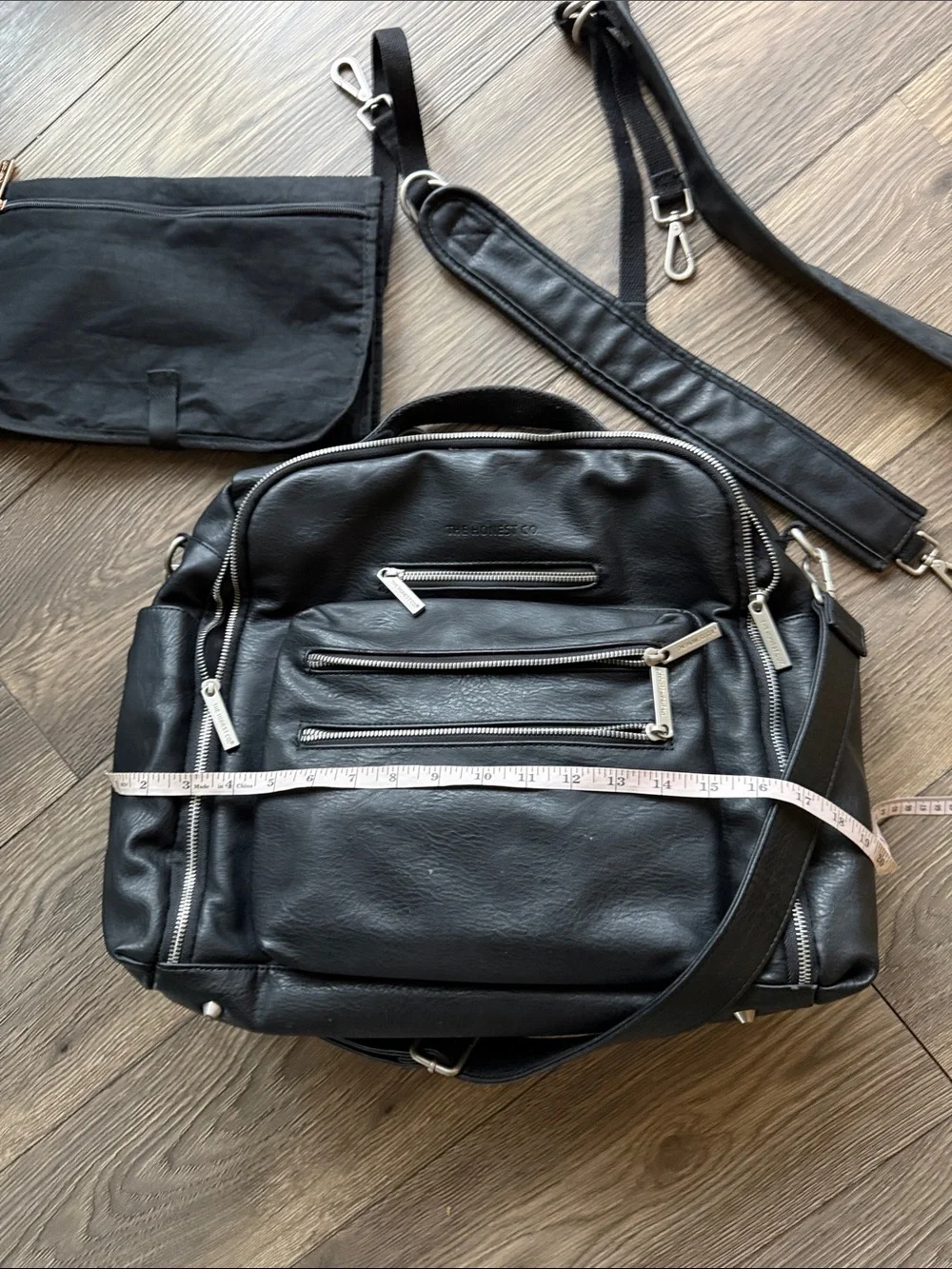 The Honest Company Black Vegan Leather Diaper Bag backpack model cross country